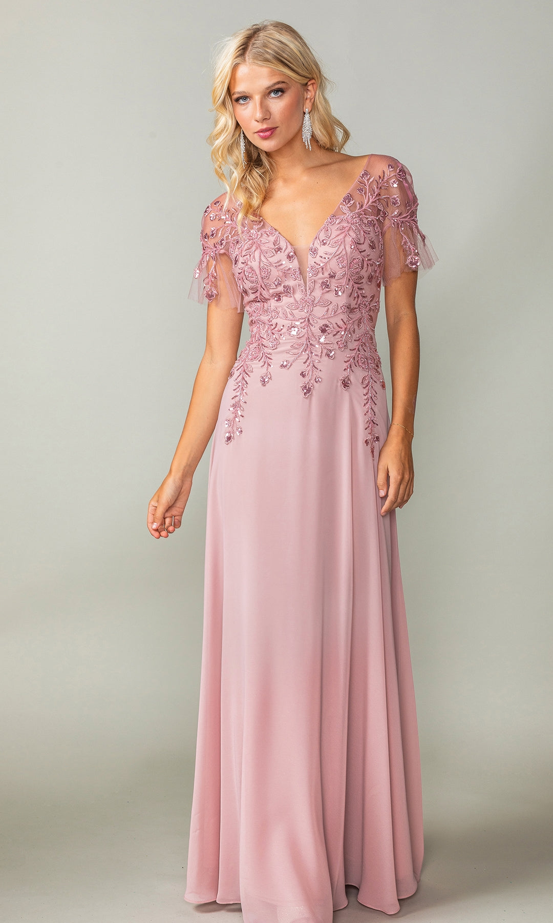 A woman stands against a plain background wearing the Dancing Queen 4378 Sheer Short-Sleeve Prom Dress, a floor-length mauve gown featuring sequin-embroidered short sleeves and a deep V-neckline.